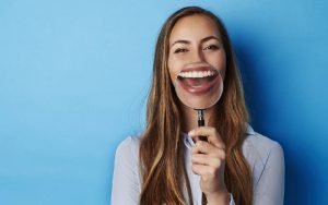 woman smiling holding up magnifying glass