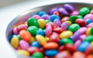 Bowl of multicolored M&Ms sitting on a white table