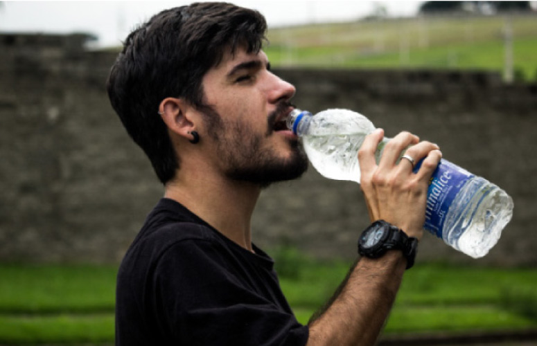 man drinking from a water bottle