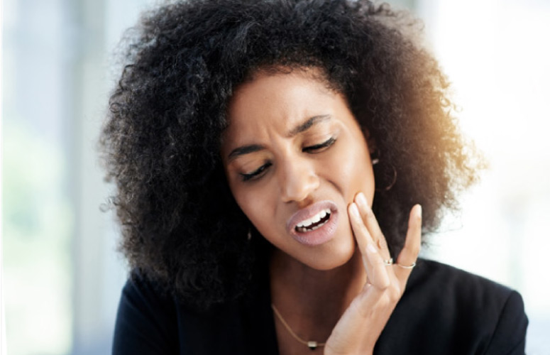 woman holding her jaw in pain with TMD