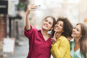 three young women take a selfie to show off their smiles