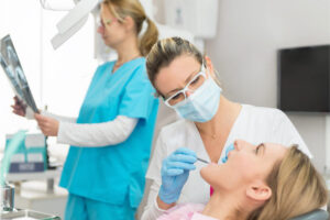 woman getting a dental exam, cleaning and x-ray
