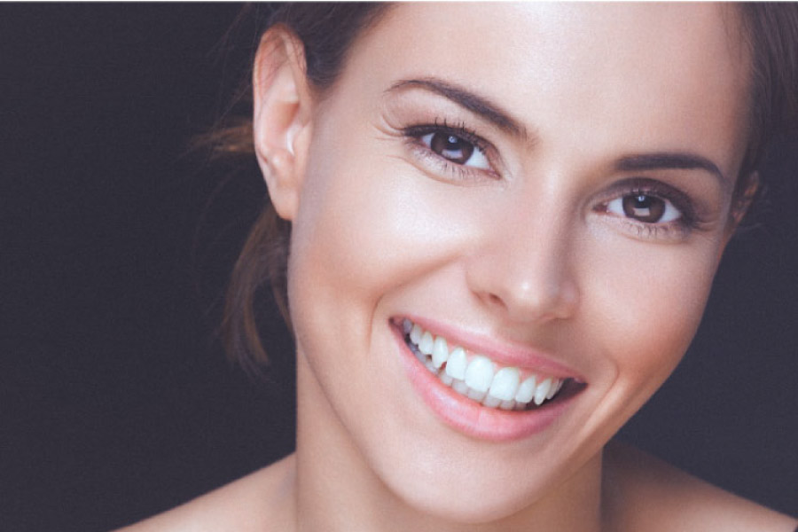 young woman smiles showing off her white, straight teeth