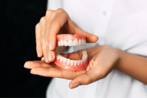 pair of dentures held in two hands