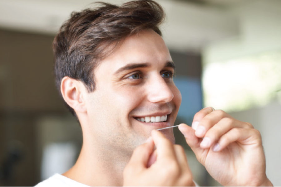 man flossing his teeth