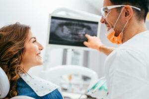 Dentist discusses a digital dental X-ray with a female patient