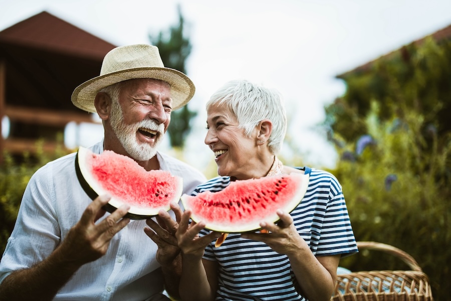 couple smiling eating summer foods for teeth like watermelon
