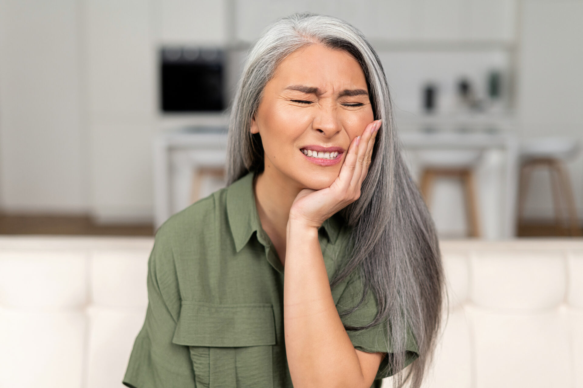 woman holding her jaw experiencing phantom tooth pain